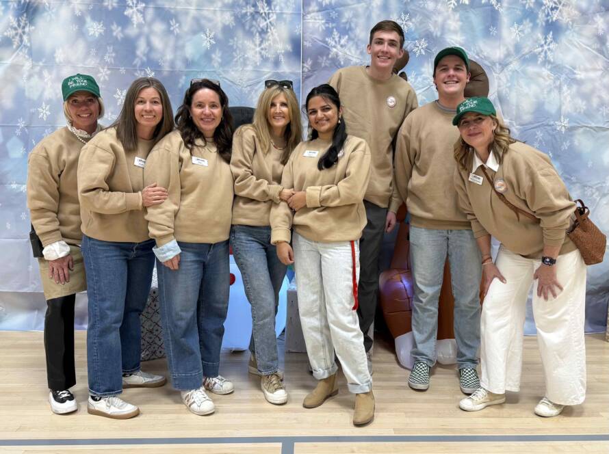 A group of volunteers and community members stand together at a Utah Refugee Connection holiday event, showing collaboration and shared support for refugees in Utah. The photo reflects how Utah Refugee Connection brings people together to serve, give, and strengthen the refugee community.