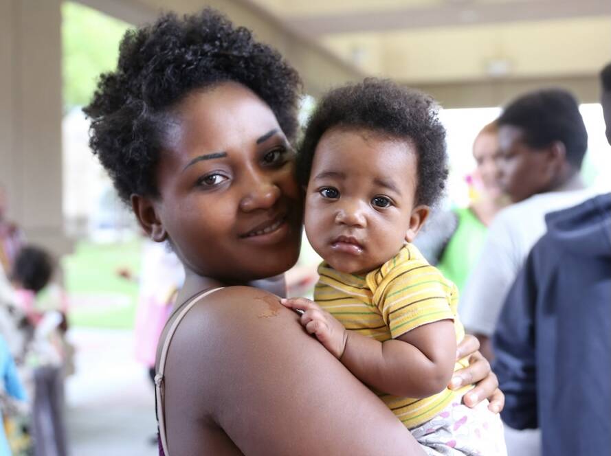 A refugee mother holds her baby during a Utah Refugee Connection gathering in Utah. Utah Refugee Connection supports refugee mothers through maternal health resources, community care, and family support programs.